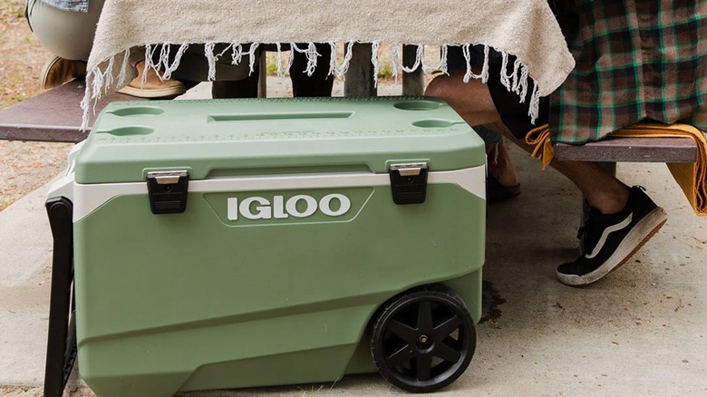An Igloo 90QT Cooler outdoors next to a picnic table