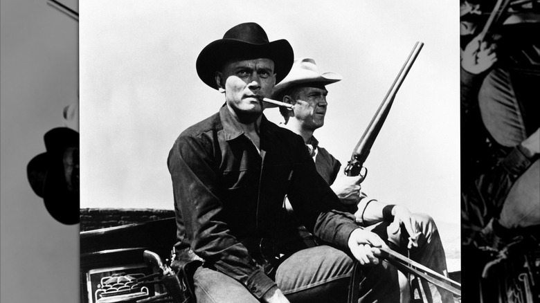 The Magnificent Seven starring Steve McQueen riding shotgun as Yul Brynner takes the reigns in a scene from the 1960 western.