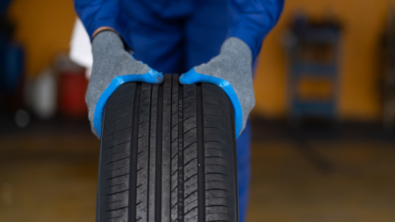 Hands holding tire with tread exposed