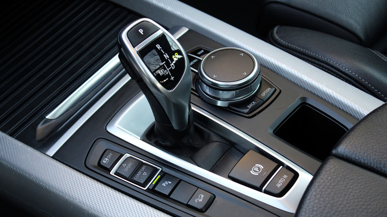 A close-up of a BMW transmission lever with driving modes and iDrive controller.