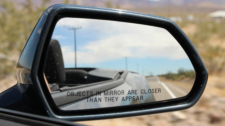 Car side mirror with text indicating objects are closer than they appear