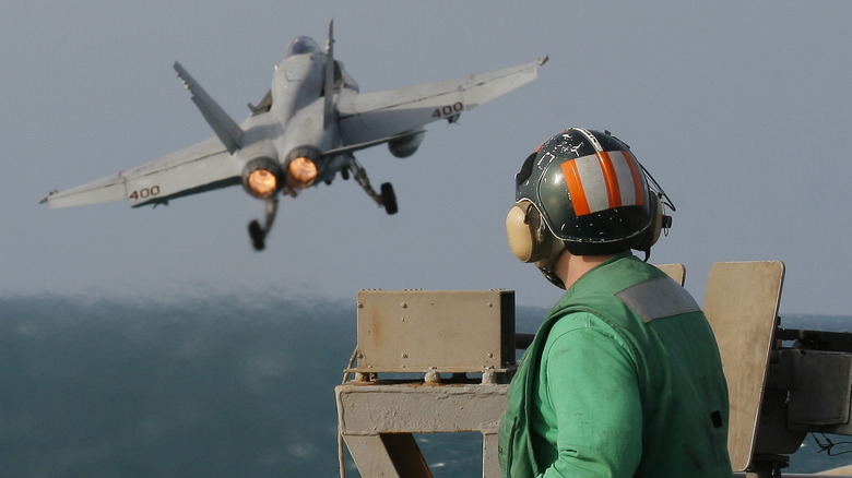 A Catapult Crewman Watches an F/A-18C Hornet Launch From the Nuclear Aircraft Carrier