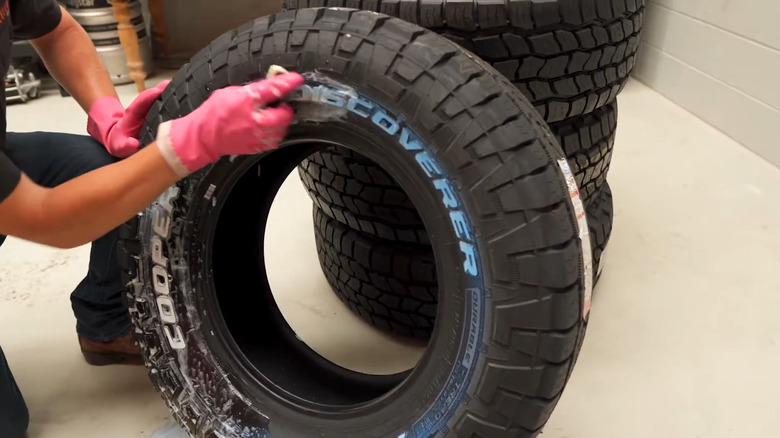 Man rubbing off blue tint from tires