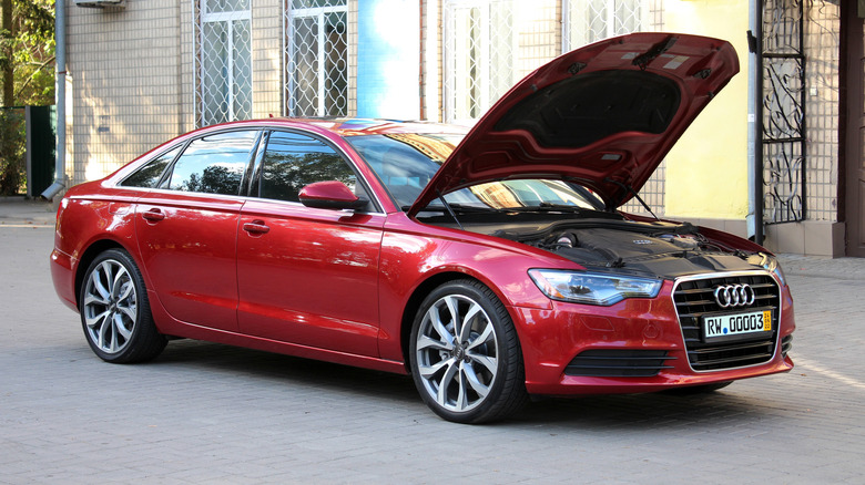 A red C7 generation Audi A6 sedan with the hood up, front 3/4 view