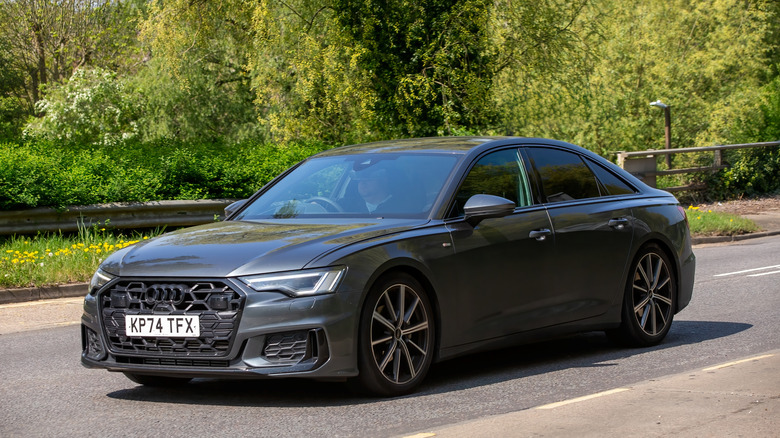 2024 Audi A6 Black Edition on the move, front 3/4 view, gray exterior