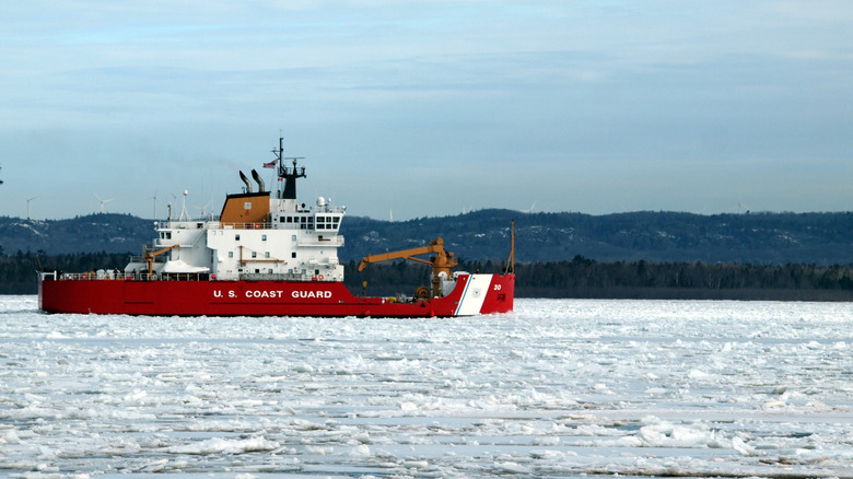 A red United States Coast Guard ship on an icy waterway