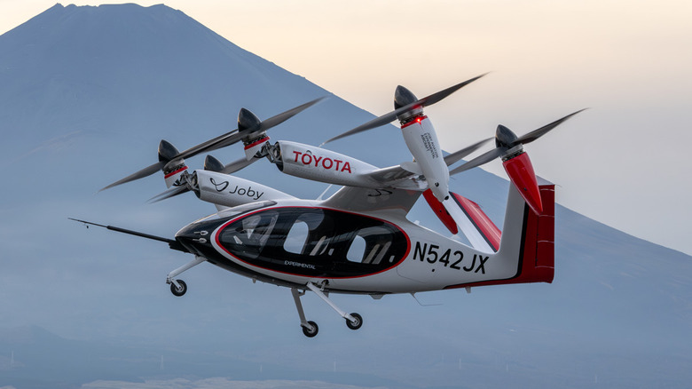 Joby eVTOL in flight going past a mountain