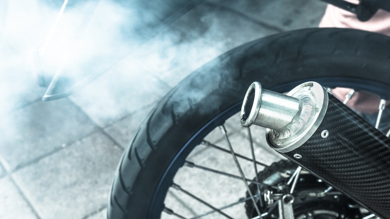 Exhaust smoke coming out of a motorcycle muffler.