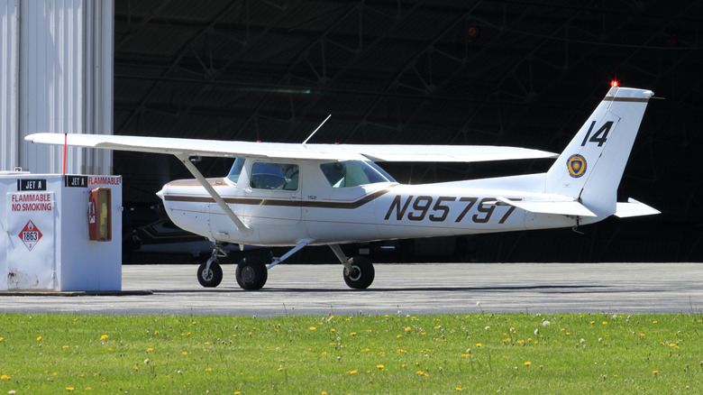 Cessna 152 parked on tarmac near hanger