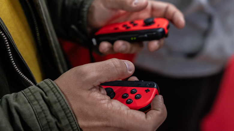 Person holding two Nintendo Switch Joy-Cons.