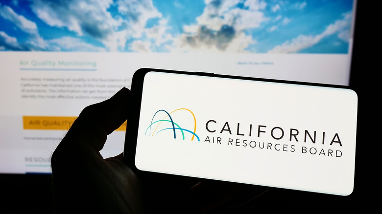 Person holding mobile phone with logo of California Air Resources Board