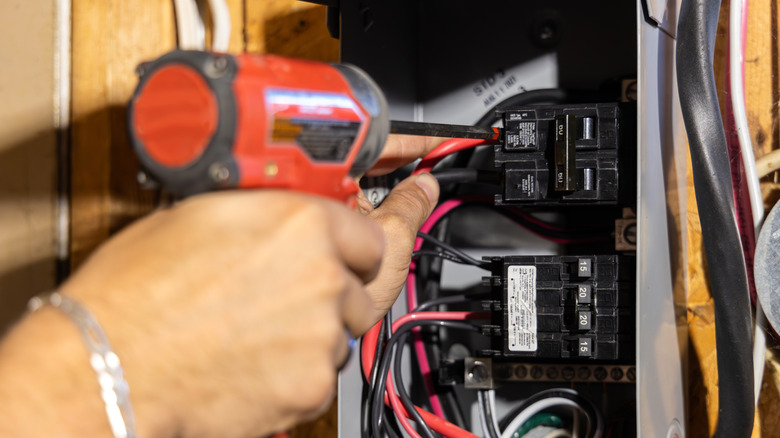 An electrician working on a circuit breaker