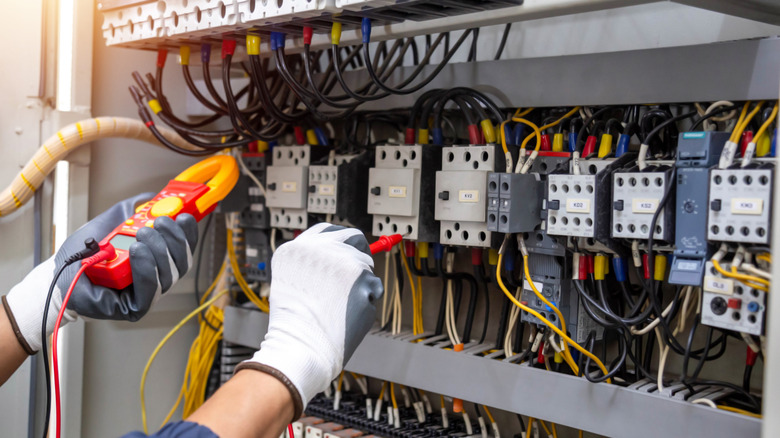 an electrician working on a circuit breaker power switchboard system