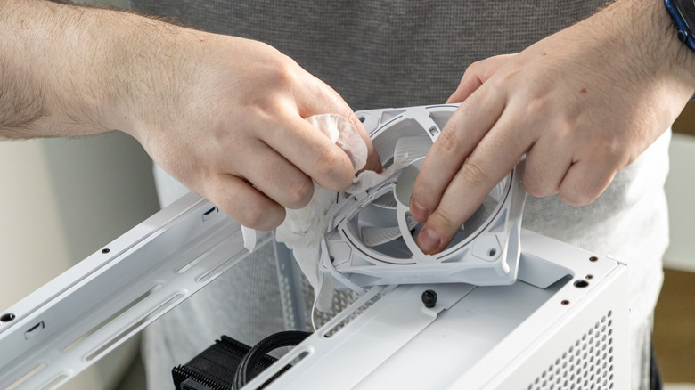 Man cleaning desktop computer fan