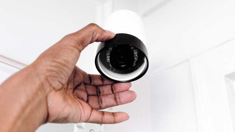 A person adjusting a security camera