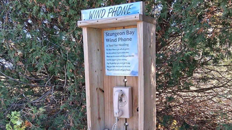 A wind phone installed among greenery.