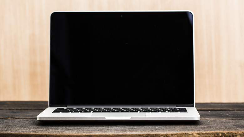 laptop with screen off on wooden table