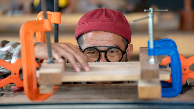 woodworking looking at clamps holding a piece on a bench