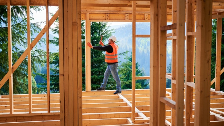 A carpenter framing in a window opening.