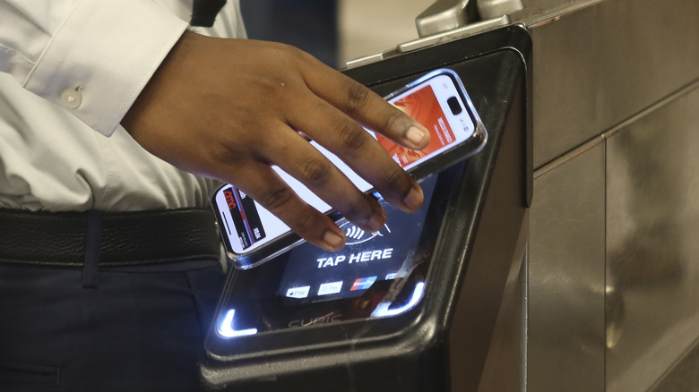 A man using a digital wallet to pay a fare