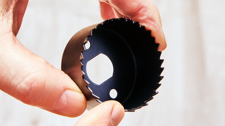 Close up of person holding hole saw