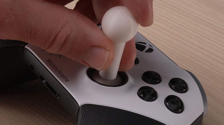 An adaptive thumbstick topper printed from Xbox Design Lab being attached to an Xbox controller.