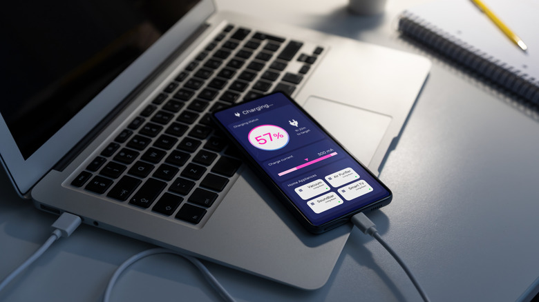 Phone plugged into laptop, charging.