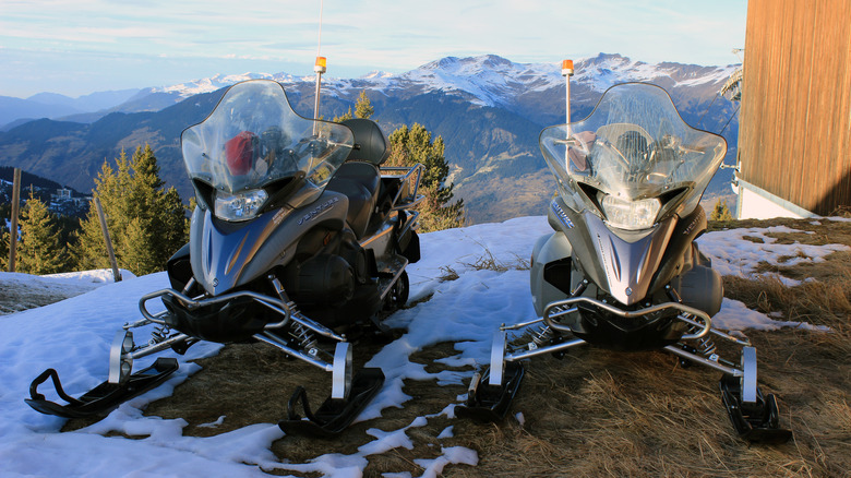 Two Yamaha snowmobiles parked at a ski resort