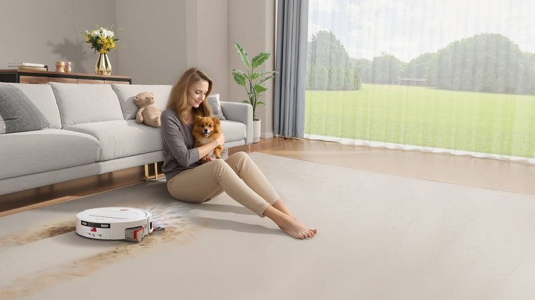 The YEEDI M14 PLUS cleaning near a woman and her dog