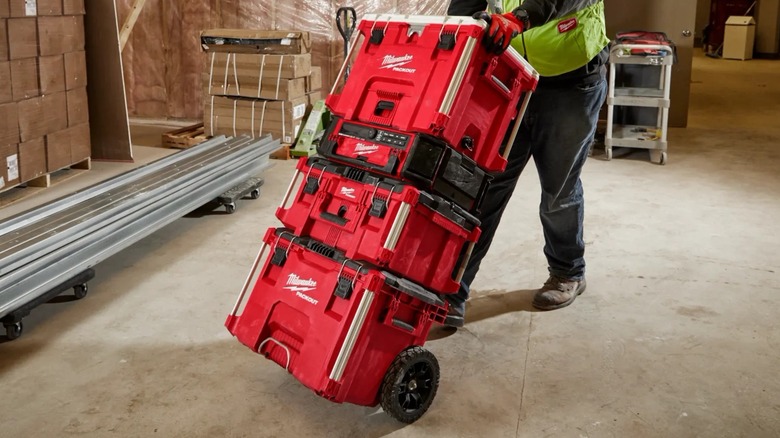 A person rolling a stack of Milwaukee Packout boxes.