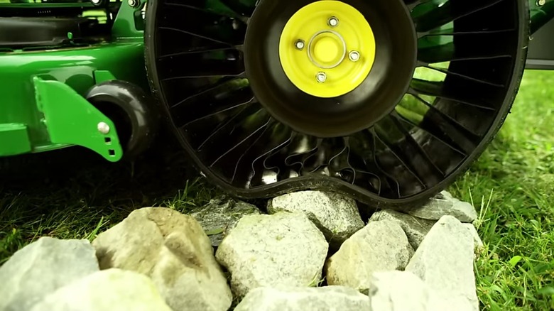 John Deere With Tweel's Rolling Over Rocks