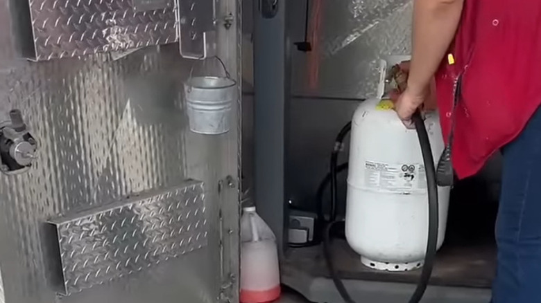 Tractor Supply employee refilling propane tank