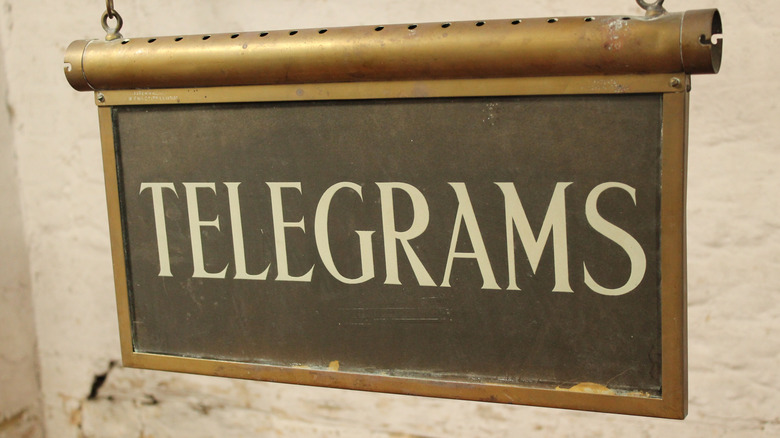 Antique telegrams sign hanging in front of a white wall