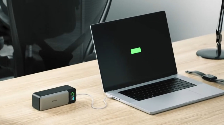 Laptop on a office desk charging via power bank.png