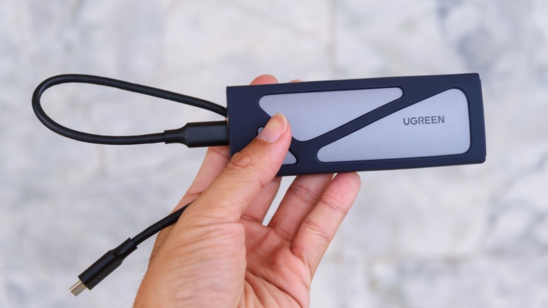 Hand holding UGREEN SSD enclosure box