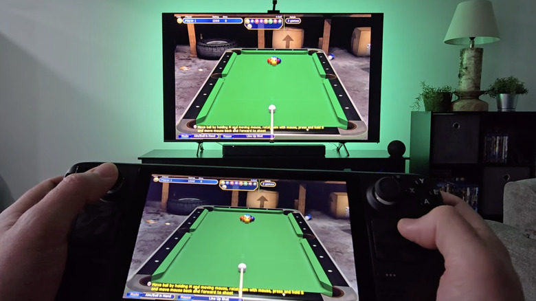 a man streams his steam deck - showing a pool game - to a tv