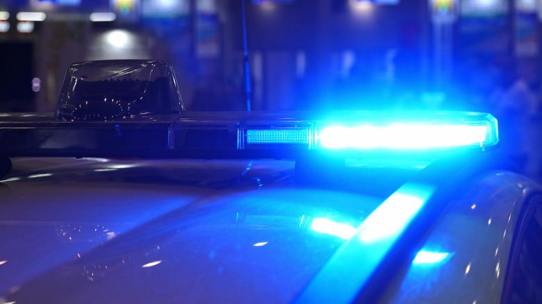 A Law Enforcement Vehicle With Blue Light At A Checkpoint