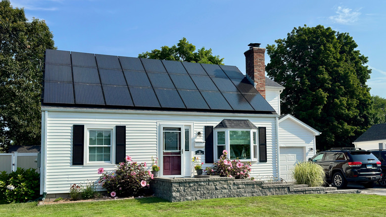 A white ranch house with solar panels on the roof
