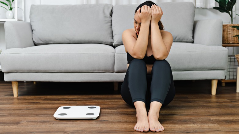 Someone anxiously looking at scale