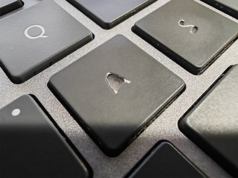 Macro close-up photo of a busted A keyboard key.