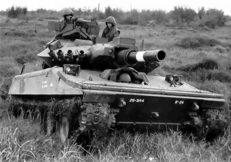 Black and white photo of M551 Sheridan tank driving through brush during the Korean War