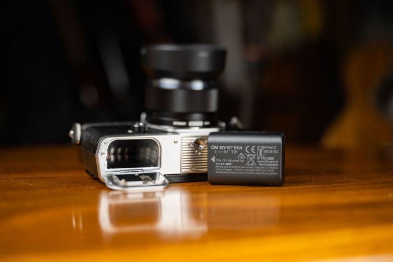 OM-3 battery and compartment open on table