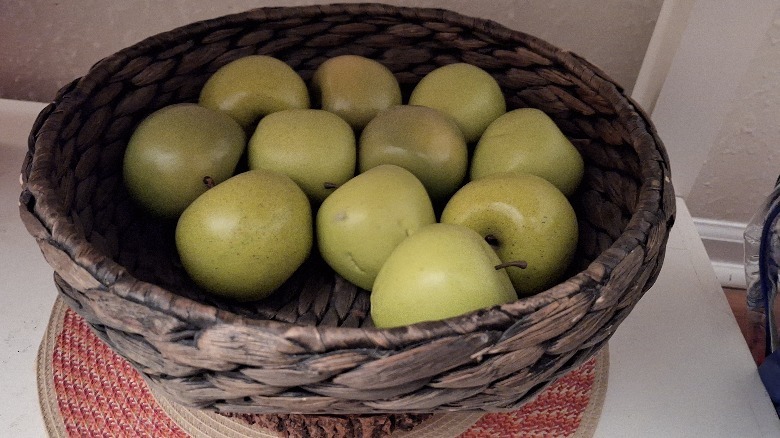 Lowlight photo of apples in a basket
