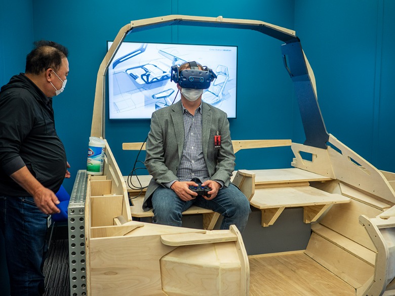 Press member trying out GM/Lockheed Martin Lunar Terrain Vehicle in VR on a wood mockup