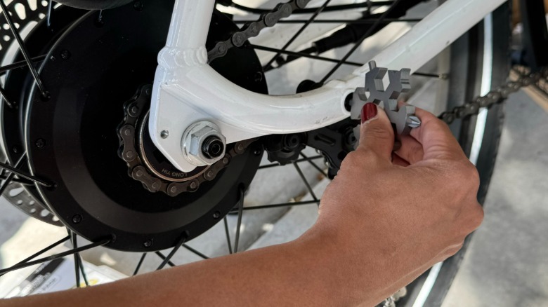 Author uses the BeTim Snowflake Multitool to make adjustments to a bicycle tire