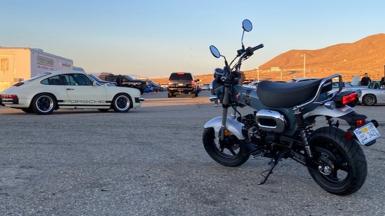 2025 Honda Dax 125 at the racetrack next to Porsche